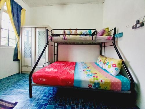 1 Schlafzimmer mit 2 Etagenbetten in einem Zimmer in der Unterkunft RANIA HOMESTAY WAKAF CHE YEH in Kota Bharu