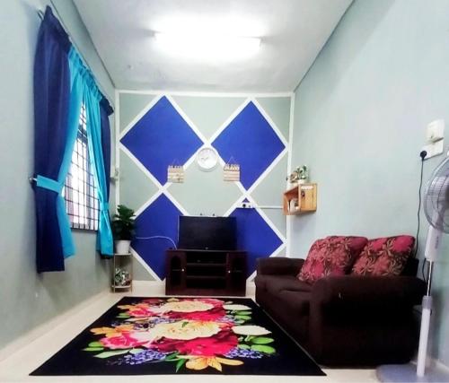 ein Wohnzimmer mit einem Sofa und einem Teppich in der Unterkunft RANIA HOMESTAY WAKAF CHE YEH in Kota Bharu