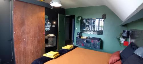 - une chambre avec un lit orange et des murs verts dans l'établissement L'usine à rêves, à Saint-Germain-du-Corbéis