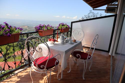 a table and chairs on a balcony with a view at Villa Castriota in Krujë