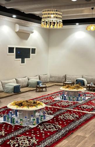una sala de estar con dos mesas con botellas de agua. en منتجعات ريفانا, en Aţ Ţuwayr