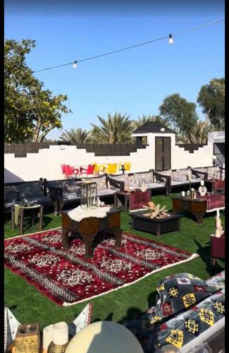 a large rug on the grass with tables and chairs at منتجعات ريفانا in Aţ Ţuwayr