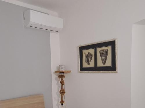pared blanca con una foto y un poste en una habitación en I Profumi del Mare en La Spezia