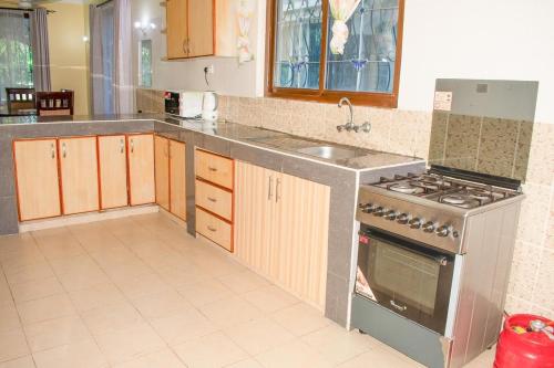 a kitchen with a stove and a sink at Kerith Springs Family Holiday home Bamburi Msa in Bamburi