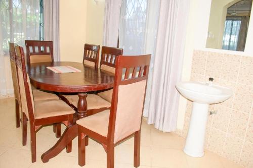 een eettafel met stoelen en een wastafel bij Kerith Springs Family Holiday home Bamburi Msa in Bamburi