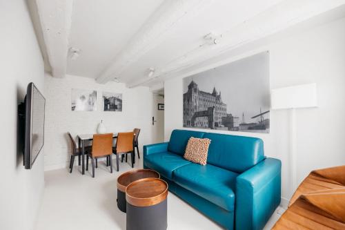 - un salon avec un canapé bleu et une table dans l'établissement YAYS Amsterdam Salthouse Canal by Numa, à Amsterdam
