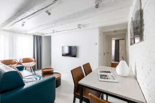 a living room with a blue couch and a table at YAYS Amsterdam Salthouse Canal by Numa in Amsterdam