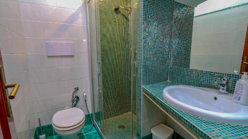a bathroom with a toilet and a shower and a sink at Appartamento Mare Nostrum - Vista Mare & A/C in Capo Coda Cavallo