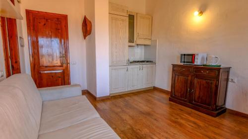 a living room with a white couch and a kitchen at Appartamento Mare Nostrum - Vista Mare & A/C in Capo Coda Cavallo