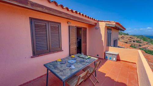 a table on the balcony of a house at Appartamento Mare Nostrum - Vista Mare & A/C in Capo Coda Cavallo
