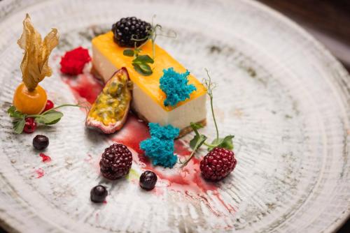 a piece of cake on a white plate with berries at UNA Hotels Bologna San Lazzaro in San Lazzaro di Savena