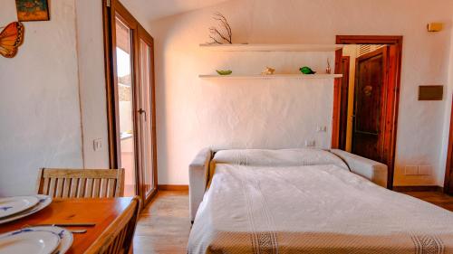 a bedroom with a bed and a table with plates on it at Appartamento Mare Nostrum - Vista Mare & A/C in Capo Coda Cavallo