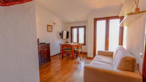 a living room with a couch and a table at Appartamento Mare Nostrum - Vista Mare & A/C in Capo Coda Cavallo