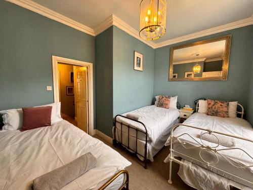 Habitación con 2 camas y espejo. en The Pickwick House 2 bedroom free parking en Bath