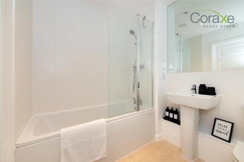 baño blanco con ducha y lavamanos en Modern 2 Bedroom Urban Oasis, en Kent