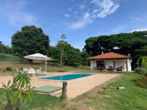 uma villa com uma piscina e uma casa em Lostpoint Home em Monte Alto