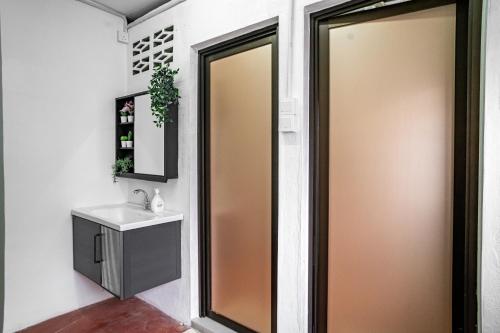 a bathroom with a mirror and a sink at Caryn Vintage Guesthouse in George Town