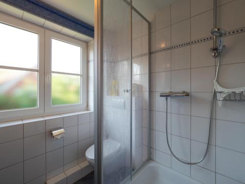 ein Bad mit einer Dusche und einem WC in der Unterkunft Trautes Haus in Spiekeroog