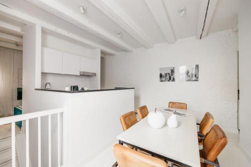 a kitchen and dining room with a white table and chairs at YAYS Amsterdam Salthouse Canal by Numa in Amsterdam