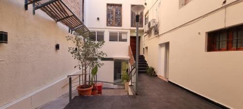 un callejón en un edificio de apartamentos con una planta en ParSur alquileres temporales Catamarca en San Fernando del Valle de Catamarca