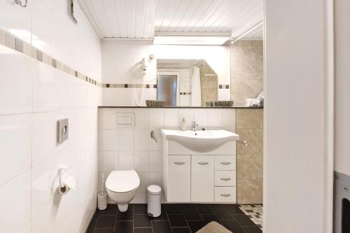 uma casa de banho branca com um WC e um lavatório em Christels Ferienwohnung 1 In Thale em Thale