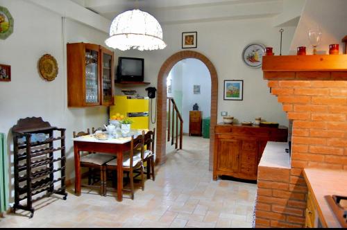 B&B Antica Dimora في بيرغولا: مطبخ وغرفة طعام مع طاولة وكراسي