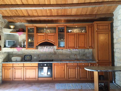 cocina con armarios de madera y mesa en Casa il Carrubbo, en Frigintini