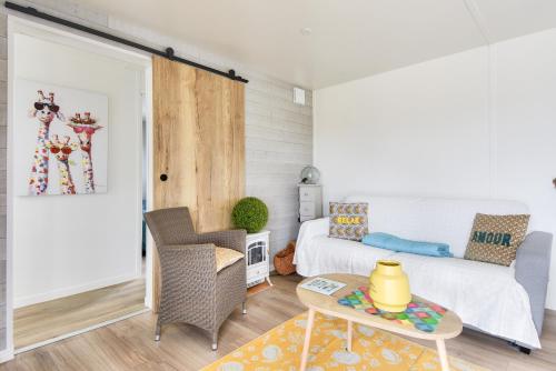 a living room with a bed and a table at Domaine calme avec piscine - Chalet pour 6 in Brétignolles-sur-Mer