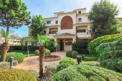a large house with a lot of bushes and trees at Luxury 3-bed apt Capanes del Golf in Benahavís