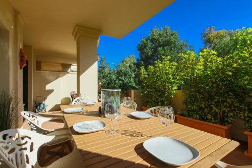a wooden table with plates and wine glasses on a patio at Luxury 3-bed apt Capanes del Golf in Benahavís