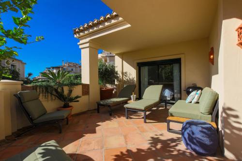 a patio with chairs and tables on a balcony at Luxury 3-bed apt Capanes del Golf in Benahavís