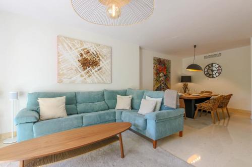 a living room with a blue couch and a table at Luxury 3-bed apt Capanes del Golf in Benahavís