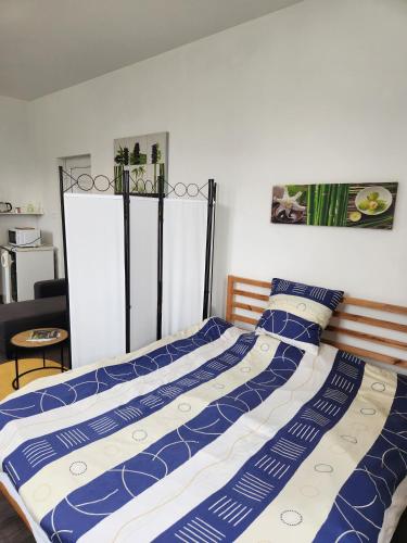 - un lit avec une couette bleue et blanche dans une chambre dans l'établissement Le Bon Samaritain, à Roucy