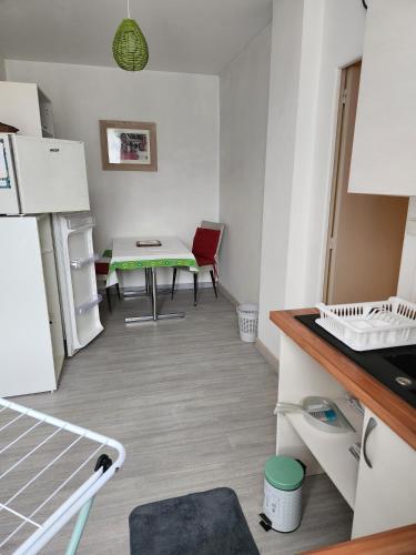 une petite cuisine avec une table et une table dans l'établissement Le Bon Samaritain, à Roucy