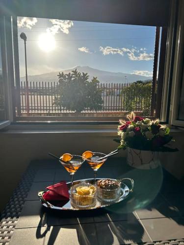 賈迪尼－納克索斯的住宿－Da Pina e Lu，窗户前桌子上装有两杯马提尼酒的托盘