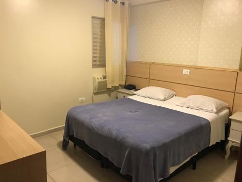 a bedroom with a large bed with two pillows at Hotel Makuxis - Brigadeiro in Sao Paulo