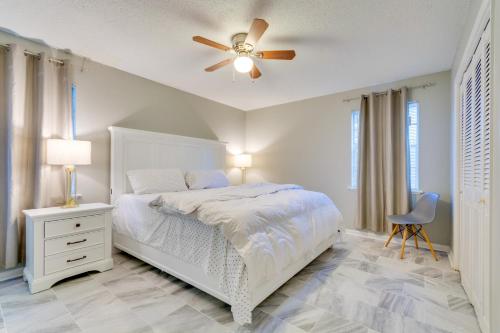 a bedroom with a white bed and a ceiling fan at Lovely Little Rock Home with Fire Pit and Yard! in Little Rock