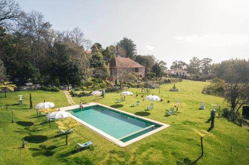a swimming pool in the middle of a grass field at Villa Camélia Boutique House in Camacha