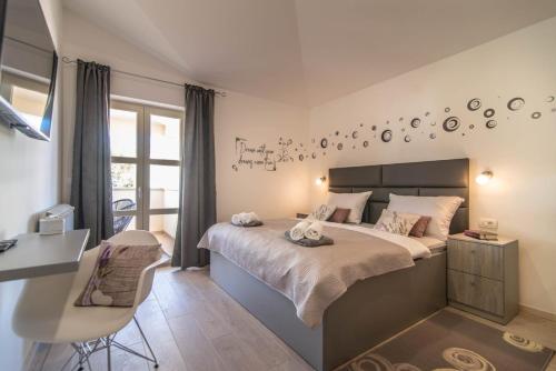 a bedroom with a bed and a desk and a window at Vila Orchidee in Poreč