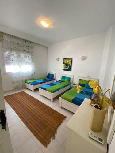 1 dormitorio con 2 camas y mesa en Dar Douja à Chaffar / Ton chez-toi près de la plage, en Nakta