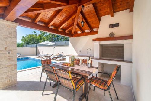 a kitchen with a table and chairs and a swimming pool at Vila Orchidee in Poreč