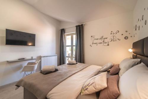 a bedroom with a large bed with a tv on the wall at Vila Orchidee in Poreč