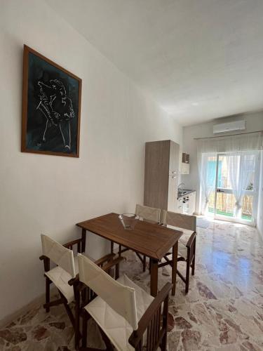 a dining room with a wooden table and chairs at VENTINOVE Apartments in Otranto