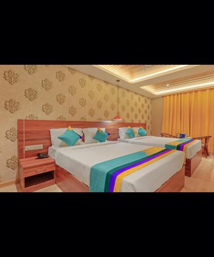 W-ONE HOTELS OOTY في أوتي: غرفة نوم مع سريرين مع ملاءات ملونة
