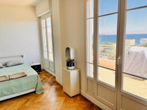 um quarto com uma cama, uma televisão e janelas em 2 bedroom flat with sea view and huge terrace em Nice