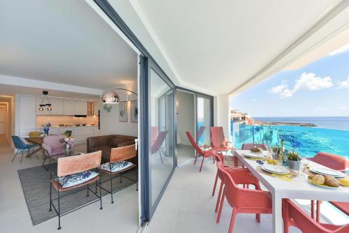 a dining room and living room with a view of the ocean at El Balcon Azul de Taliarte by VillaGranCanaria in Telde