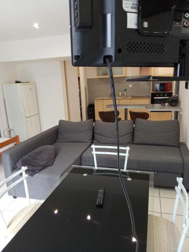 un salon avec un canapé et une télévision au-dessus dans l'établissement Studio meublé 3 personnes plien pieds, à Saint-Rambert-dʼAlbon