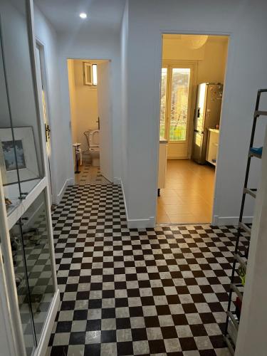 - un couloir avec un sol en damier dans une maison dans l'établissement 2 bedroom flat with sea view and huge terrace, à Nice