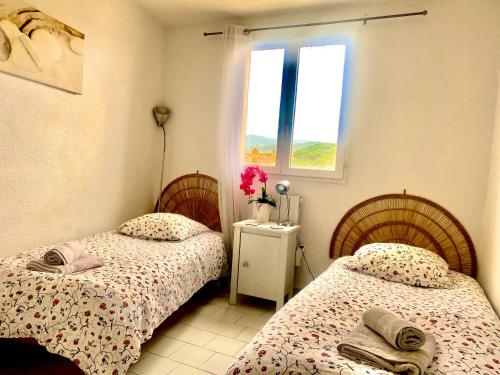 2 Einzelbetten in einem Zimmer mit Fenster in der Unterkunft Modern, 2 bedrooms, Aircon, pool & fiber optic in a quiet, private gated domain 5kms to St Tropez in Cogolin