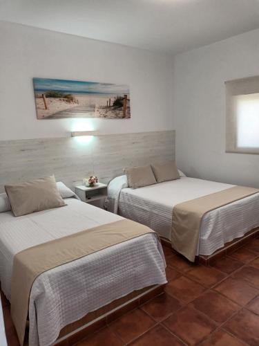 two beds in a hotel room with two beds at Hostal Los Mellizos in Conil de la Frontera